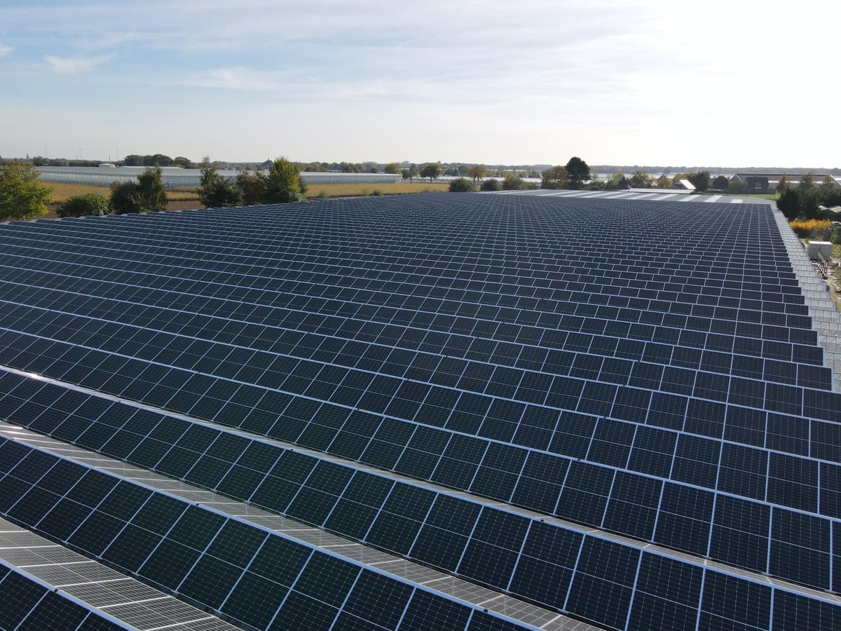 Zonnepanelen op het dak van een bedrijfspand bij zonsondergang